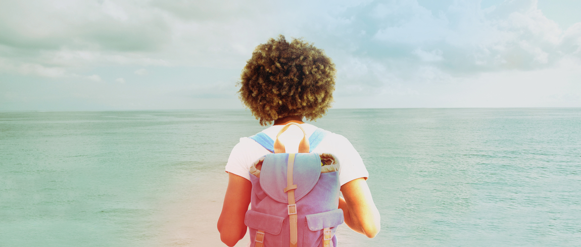 Woman with backpack looking toward the horizon