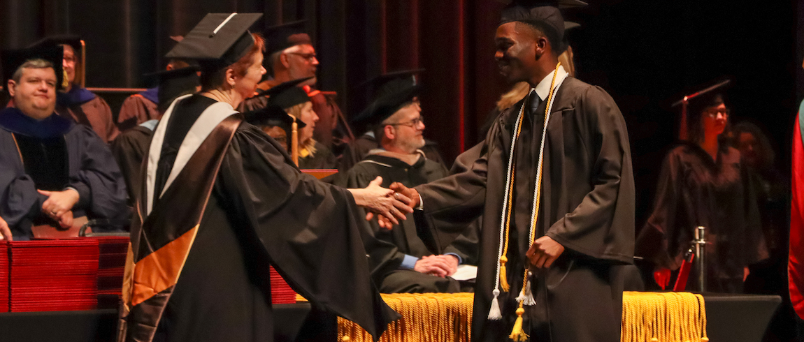 Lake Michigan College Board of Trustees Secretary Vicki Burghdoff congratulates a graduating student during the 75th commencement ceremonies on May 1, 2022.