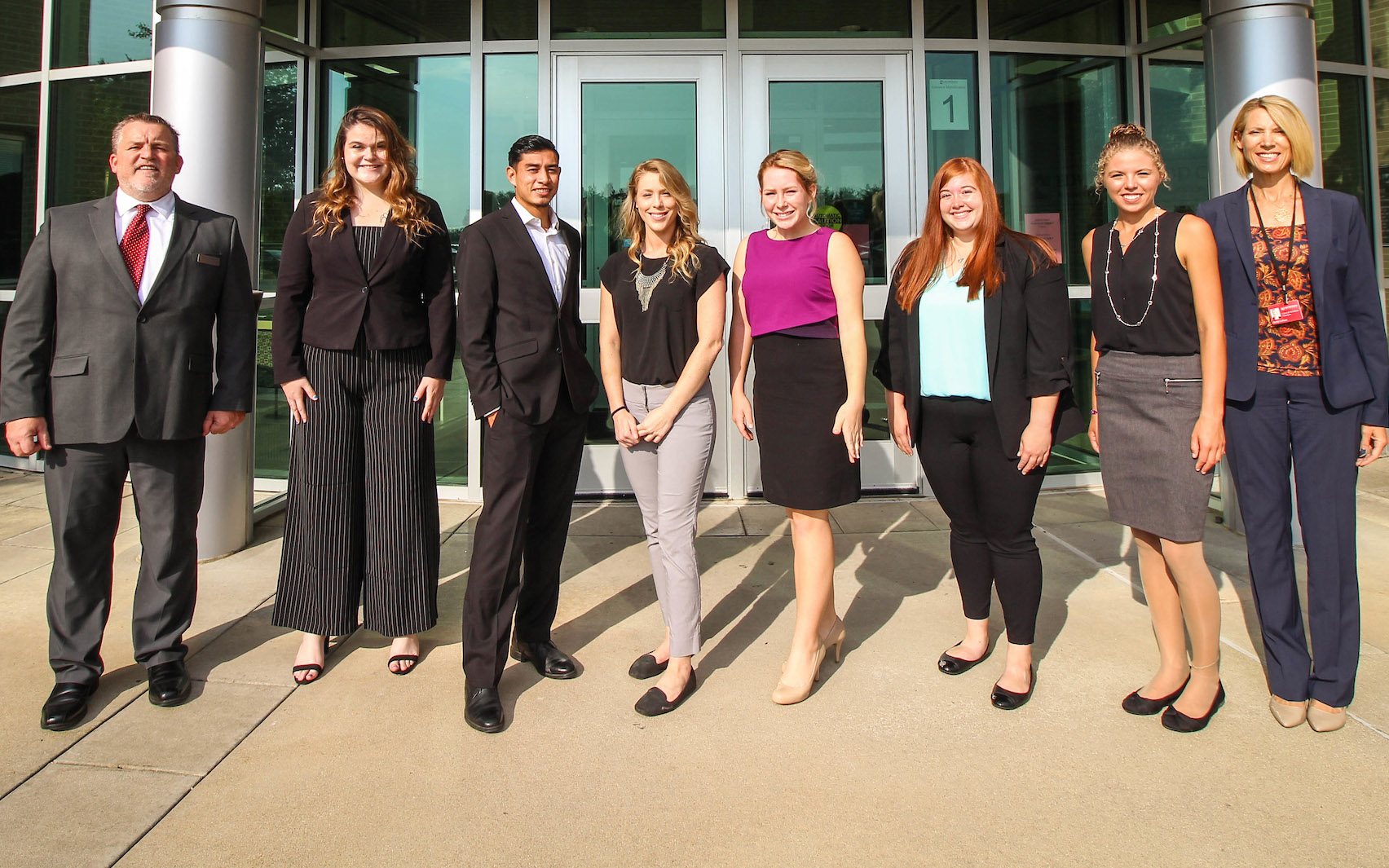 Women in Business club members and advisors dressed professionally and posing in front of the main Benton Harbor Campus entrance.