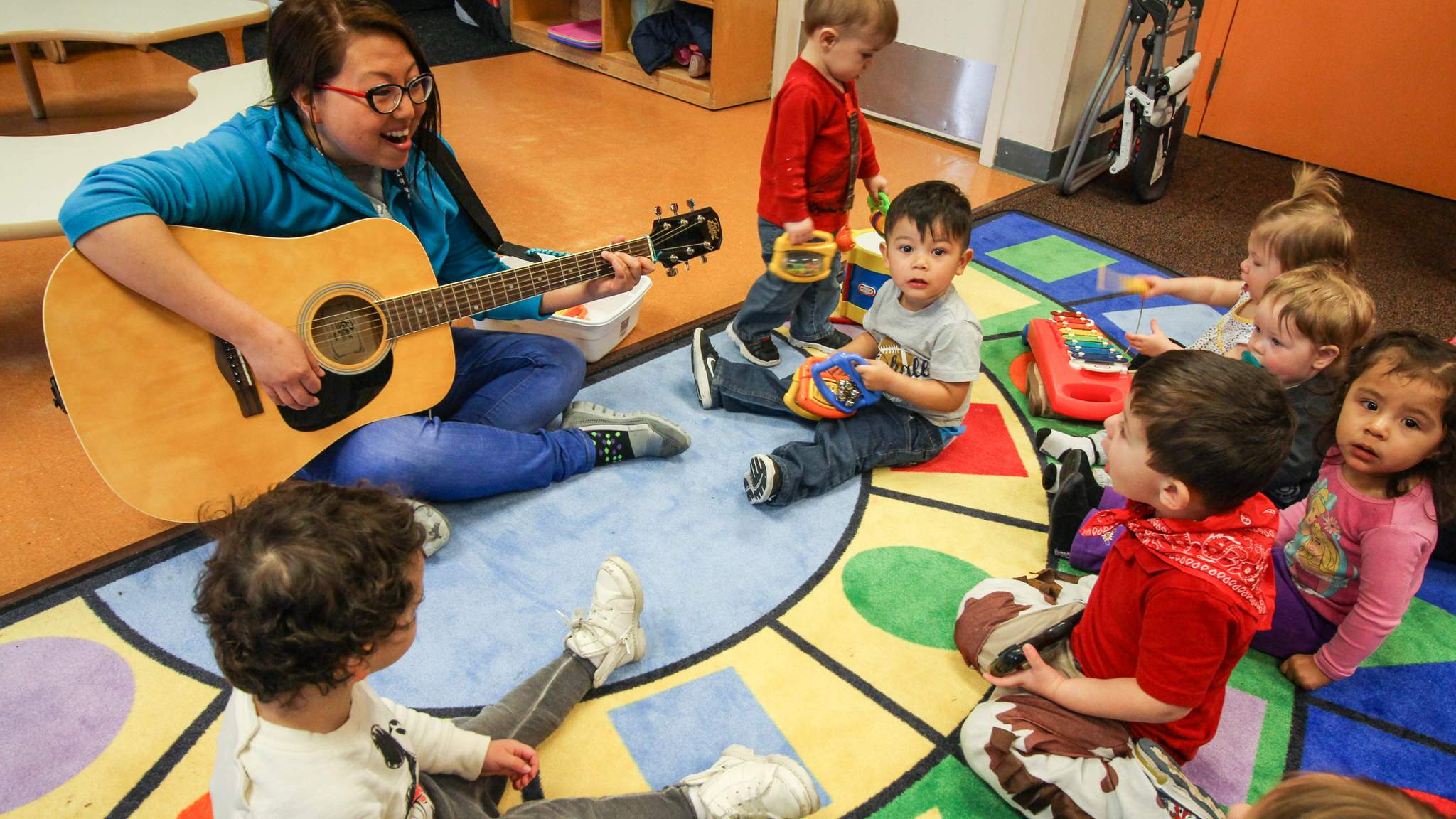 Kids with teacher playing music at Kidzone