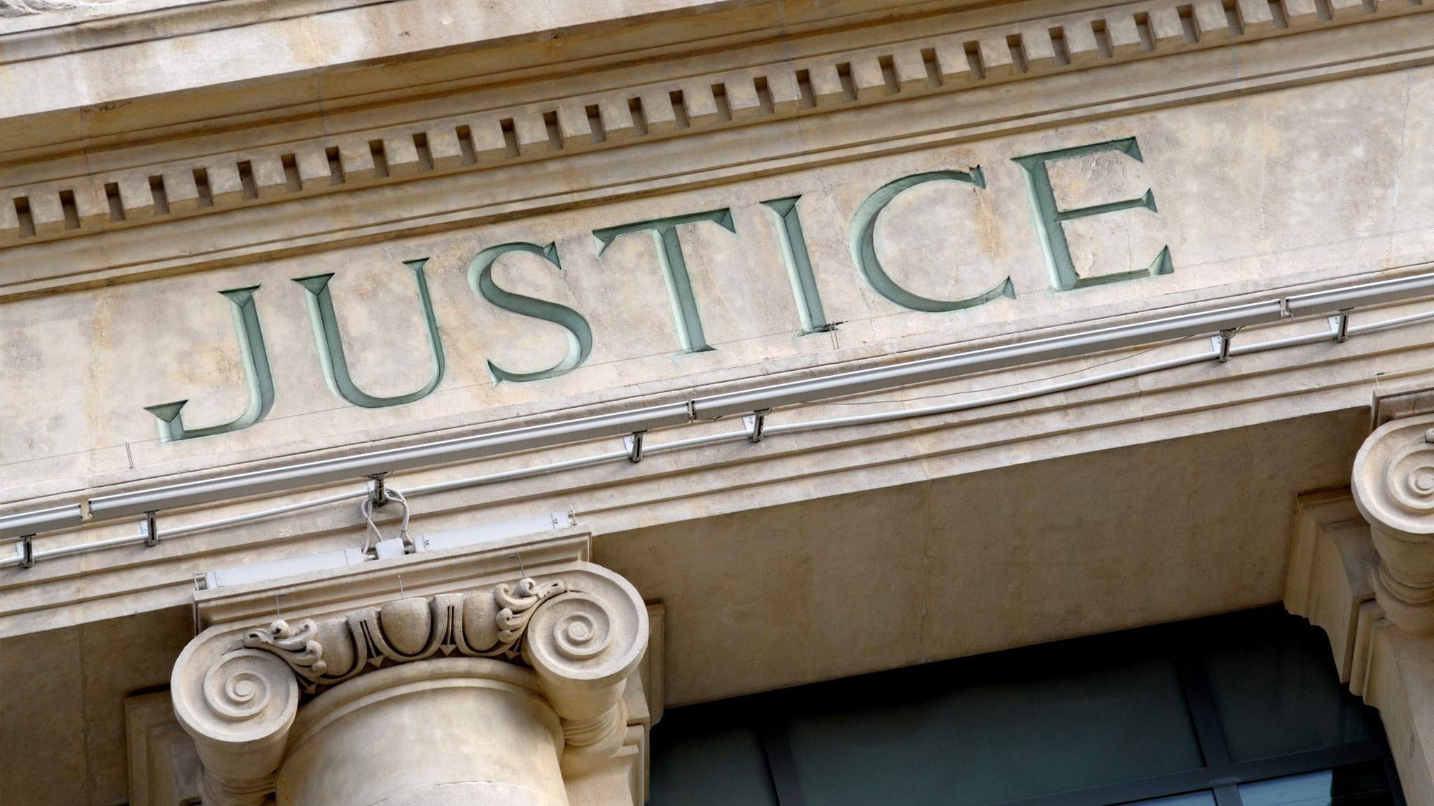 "Justice" carved above a doorway.