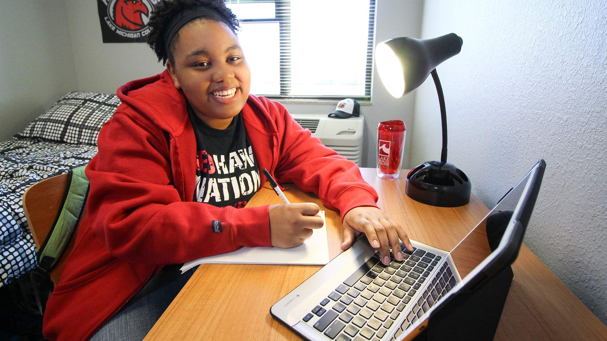 Student studying at desk in dorm room