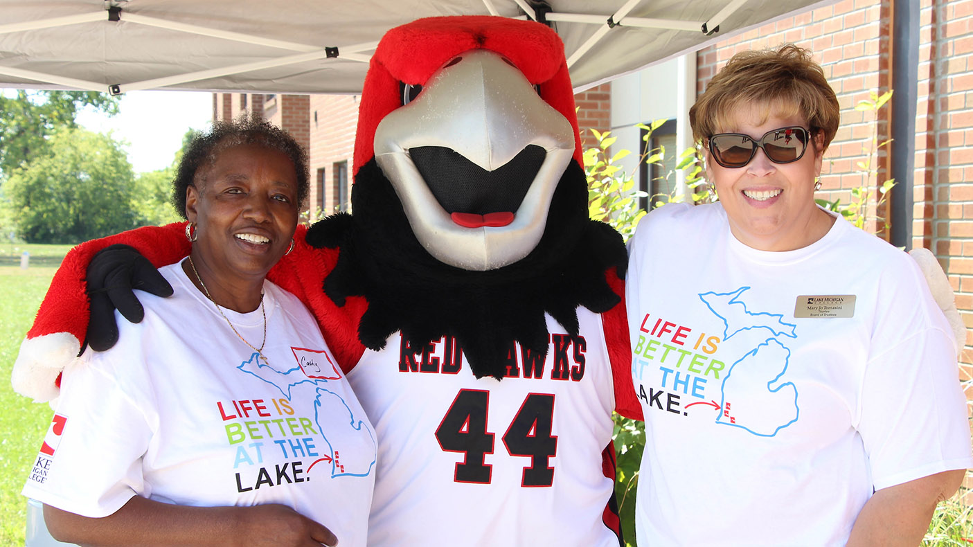 Alumnae posing with Rocky the RedHawk