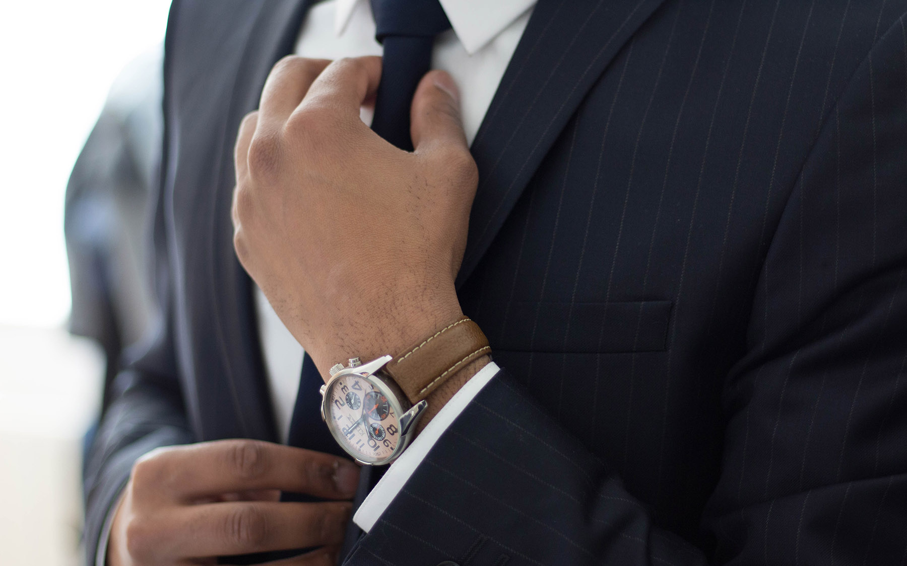 Person in a business suit adjusting their tie.