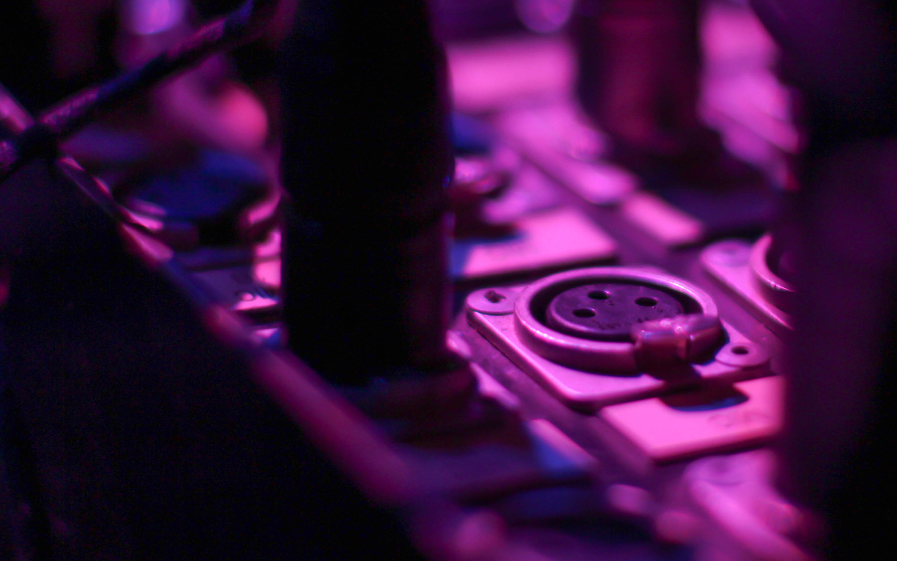 Sound equipment in a purple light from stage