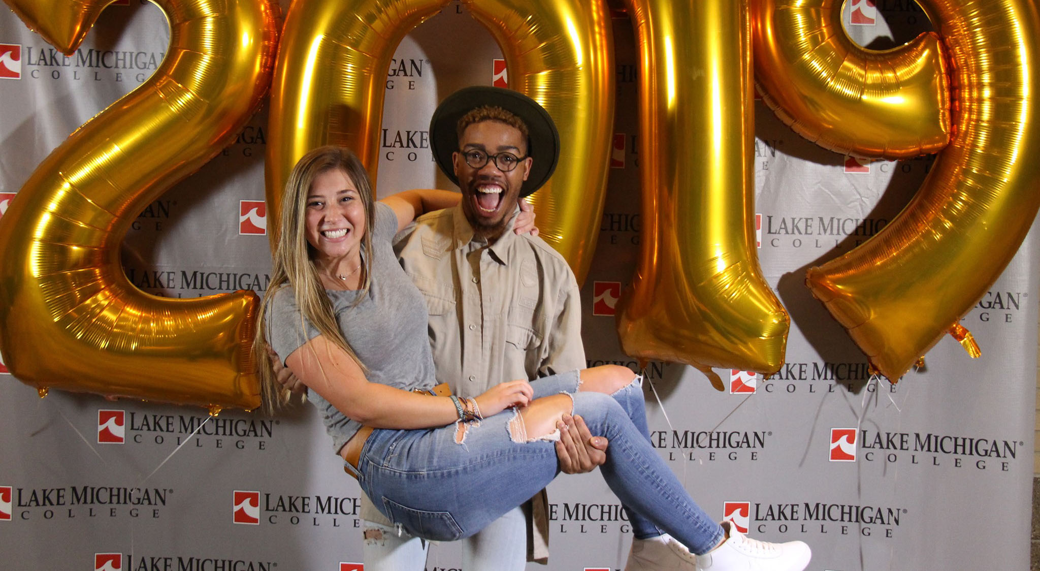 LMC students Uriah and Paige Pose in front of 2019 balloons