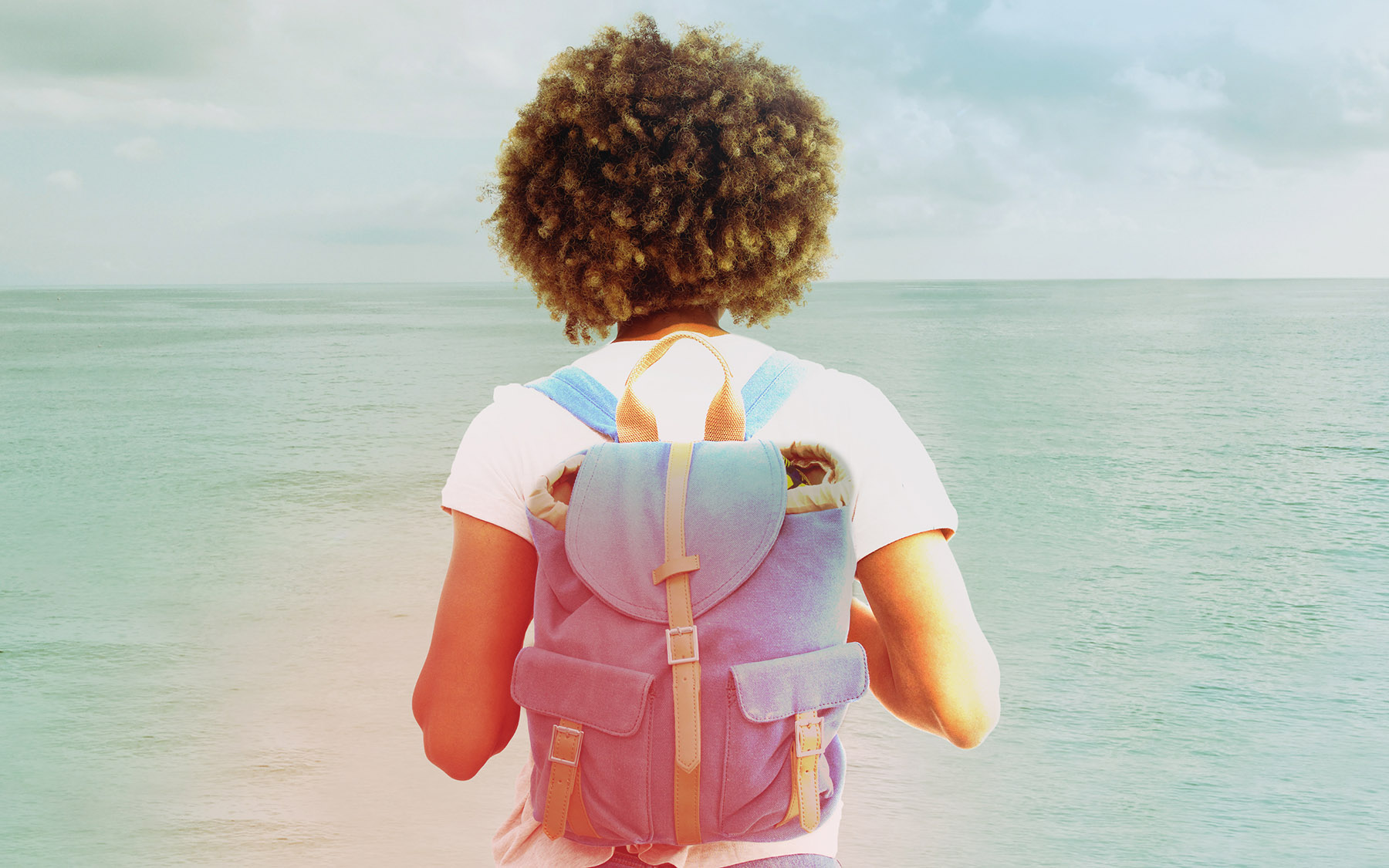 Woman with backback looks out over Lake Michigan.