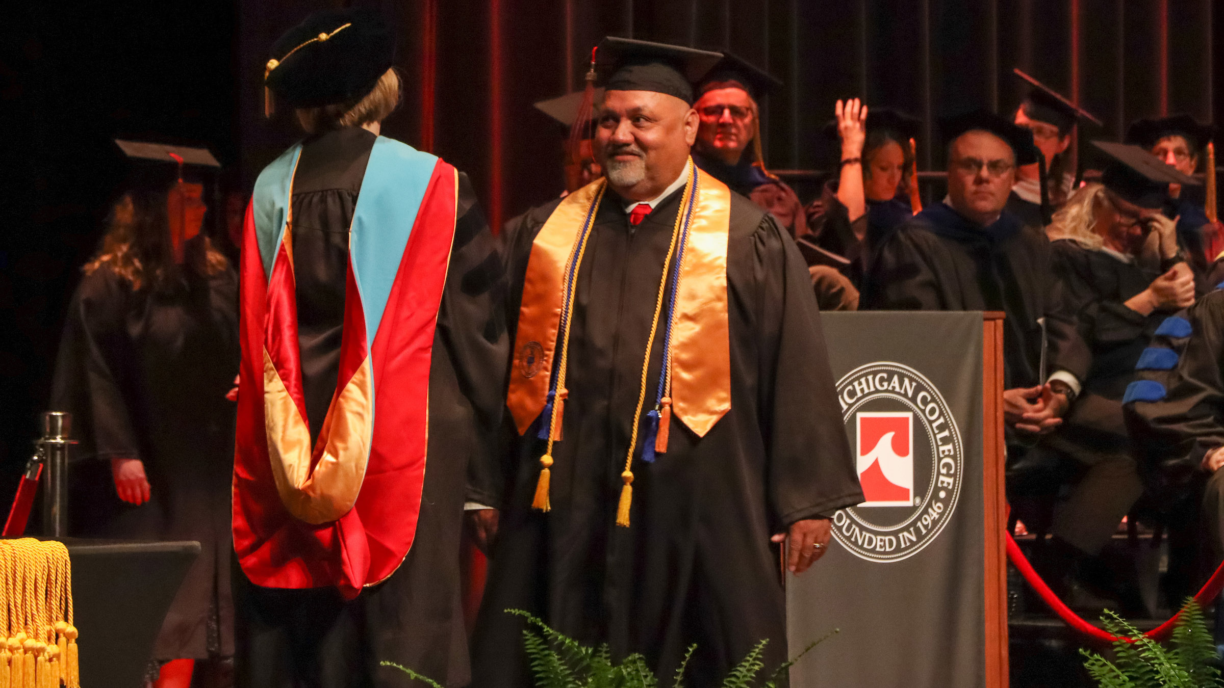 Non-traditional student receiving his honor cords at commencement.