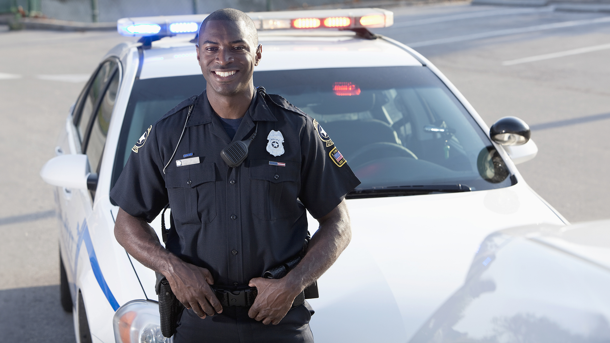 Police officer in front of a police car