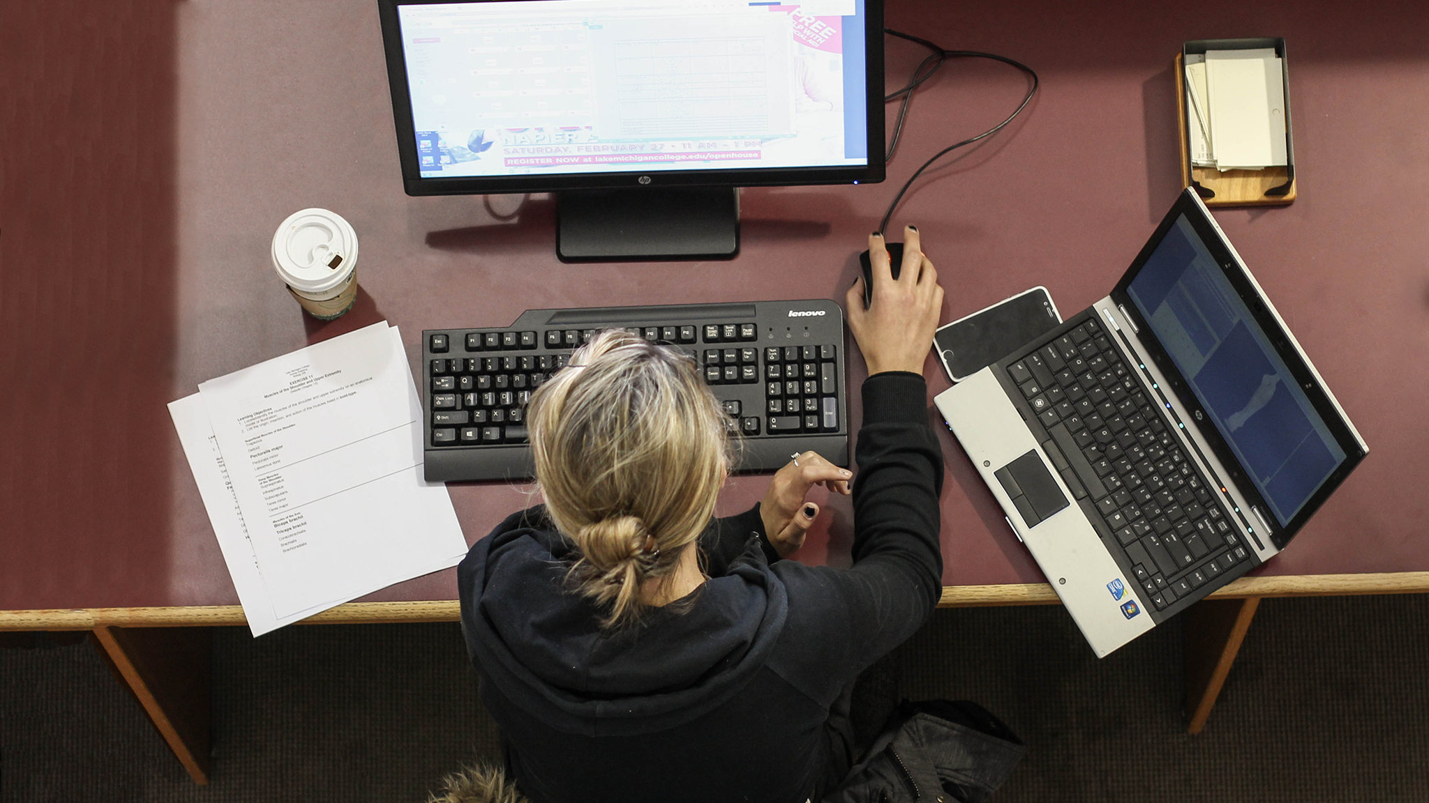 Top-down view of a woman working at her desk with a computer