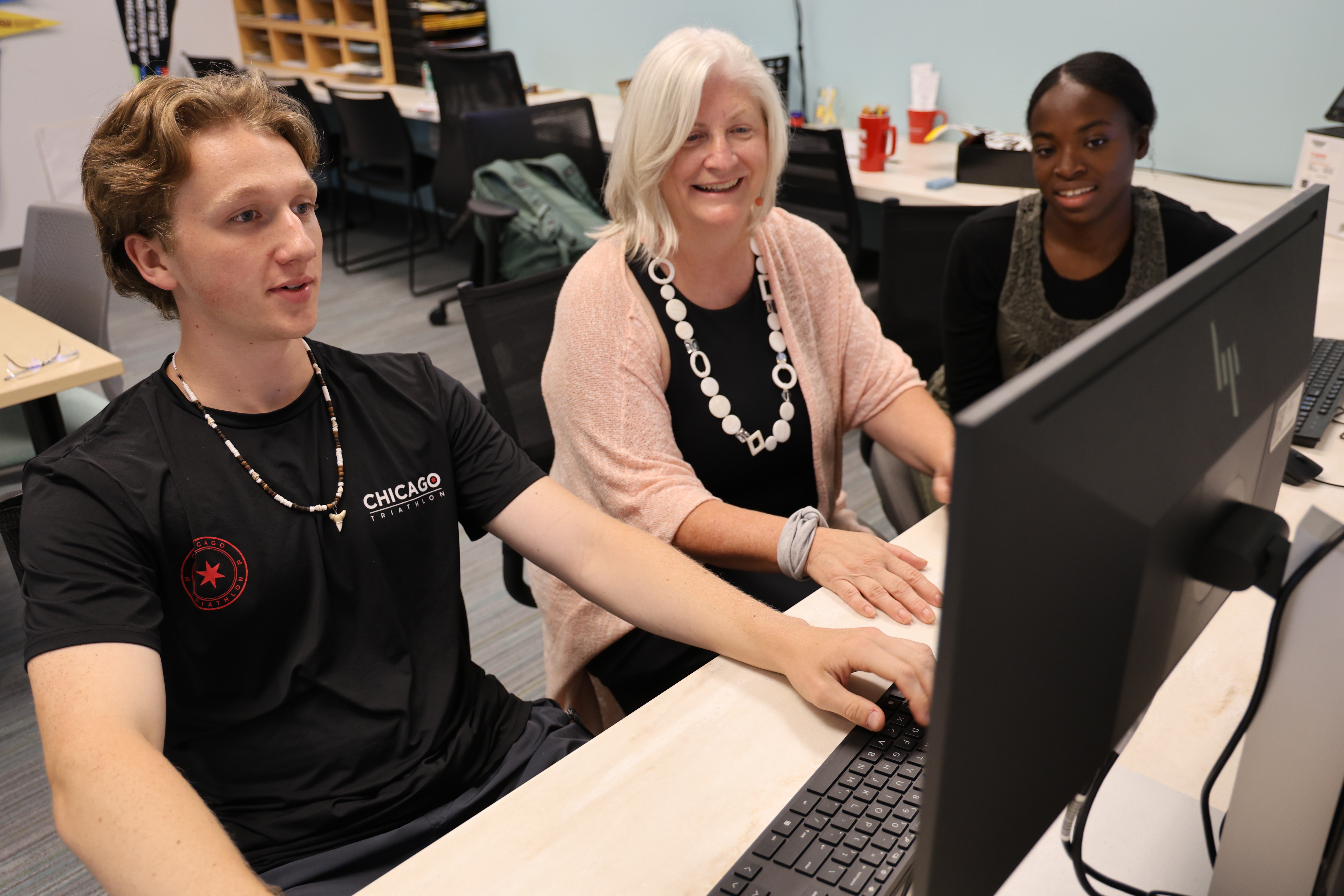 Several people looking at a computer monitor together