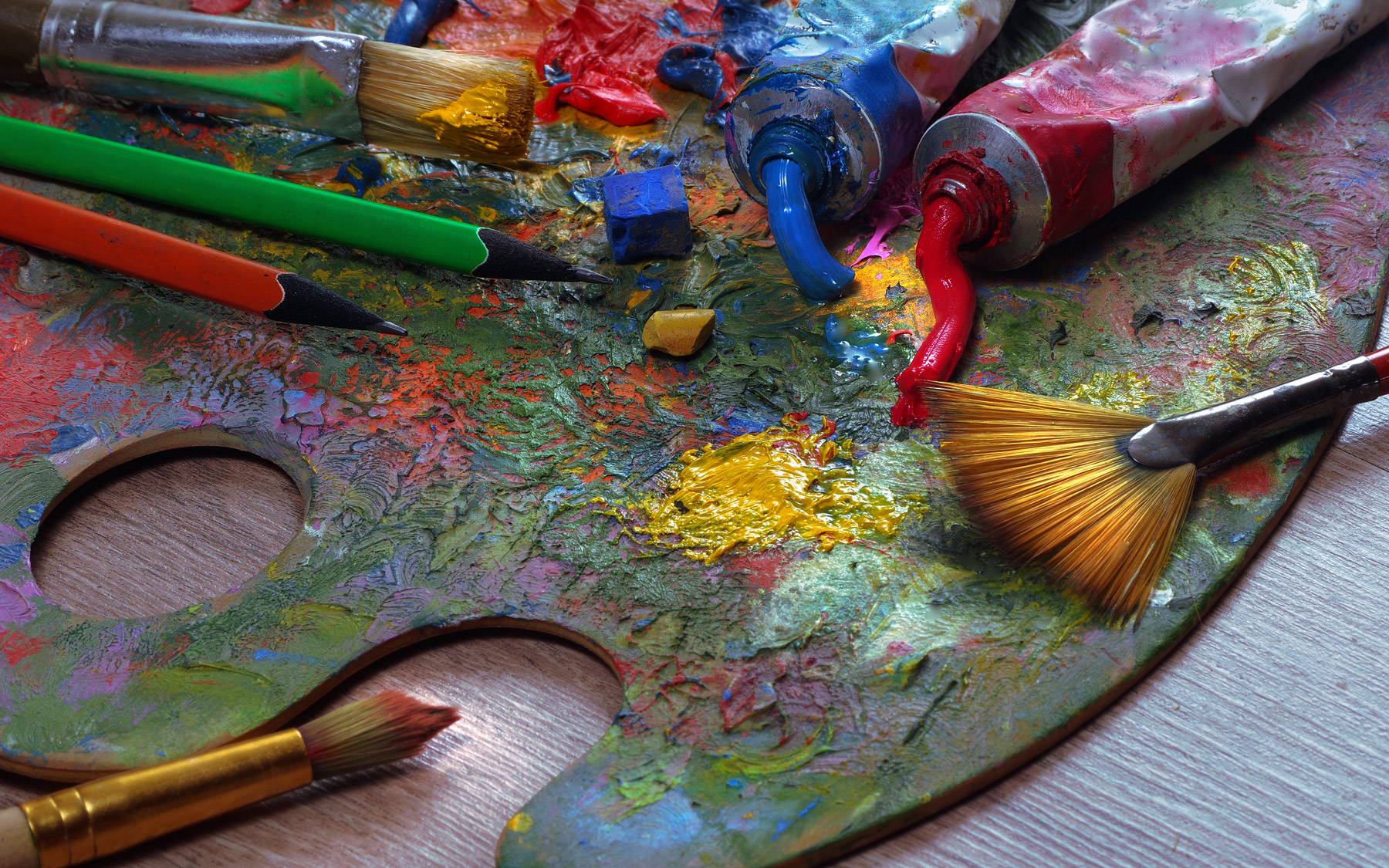 Artist's palette, tubes and brushes on a table.