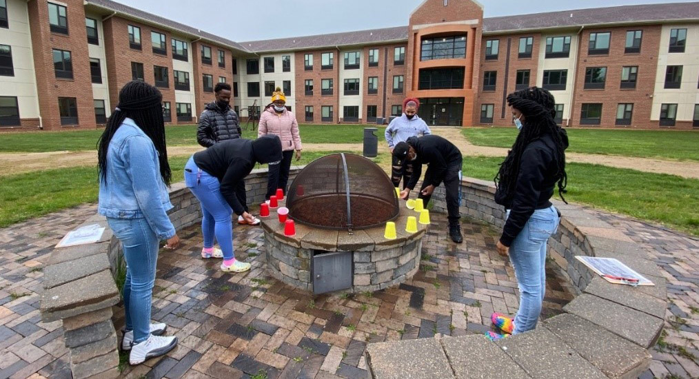 Upward Bound students around the firepit at LMC's residence hall.