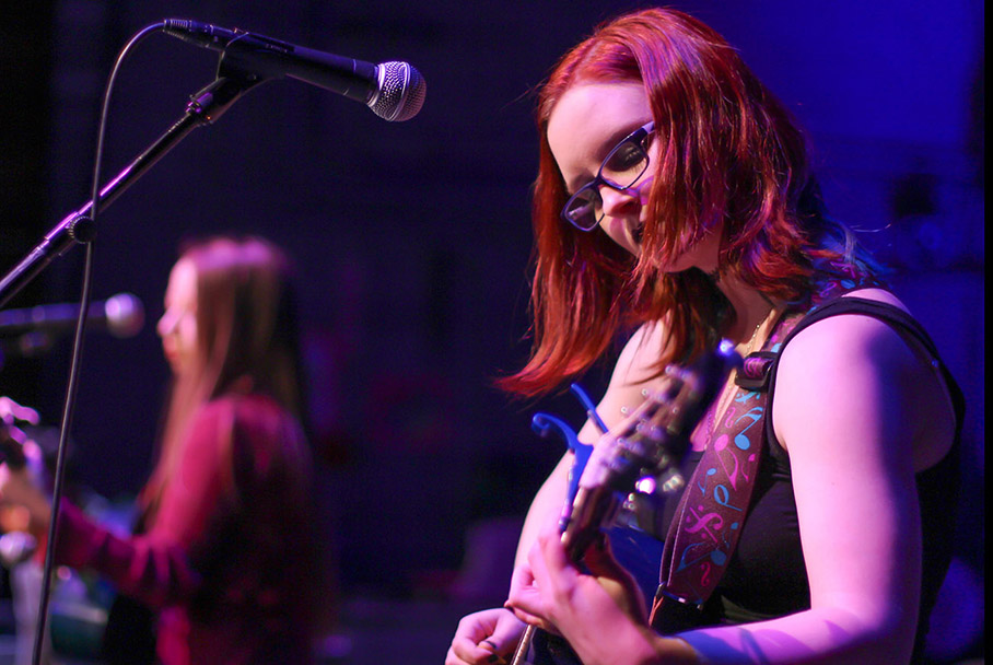 Woman playing a guitar on stage