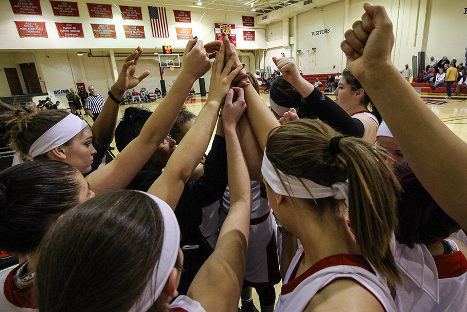 Women's basketball team in a huddle