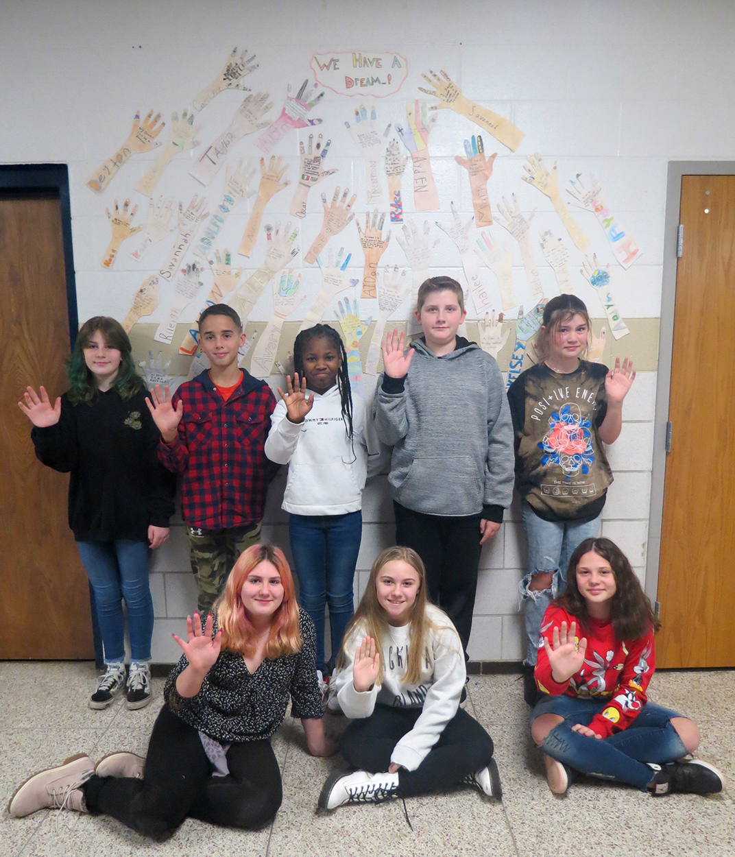 Eight of the students in front of their art.