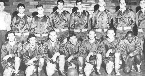 The basketball team poses in their shiny warm-up jackets.