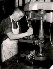 Young man uses a lathe.