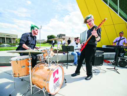 Students playing drums, guitars and keyboard at the grand opening of the Hanson Technology Center.