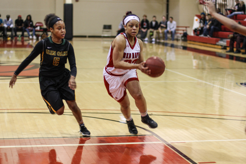 A member of the women's basketball team goes in for a basket.