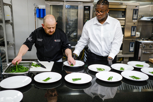 Chef Amado demostrating plating to a student in the new kitchen.