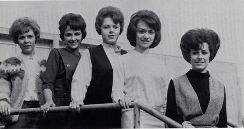 Five women with short, puffy hair posing outside a dance.