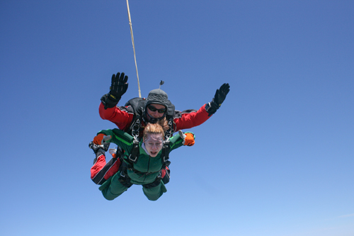A student and a skydiving instructor in mid-air after a jump.