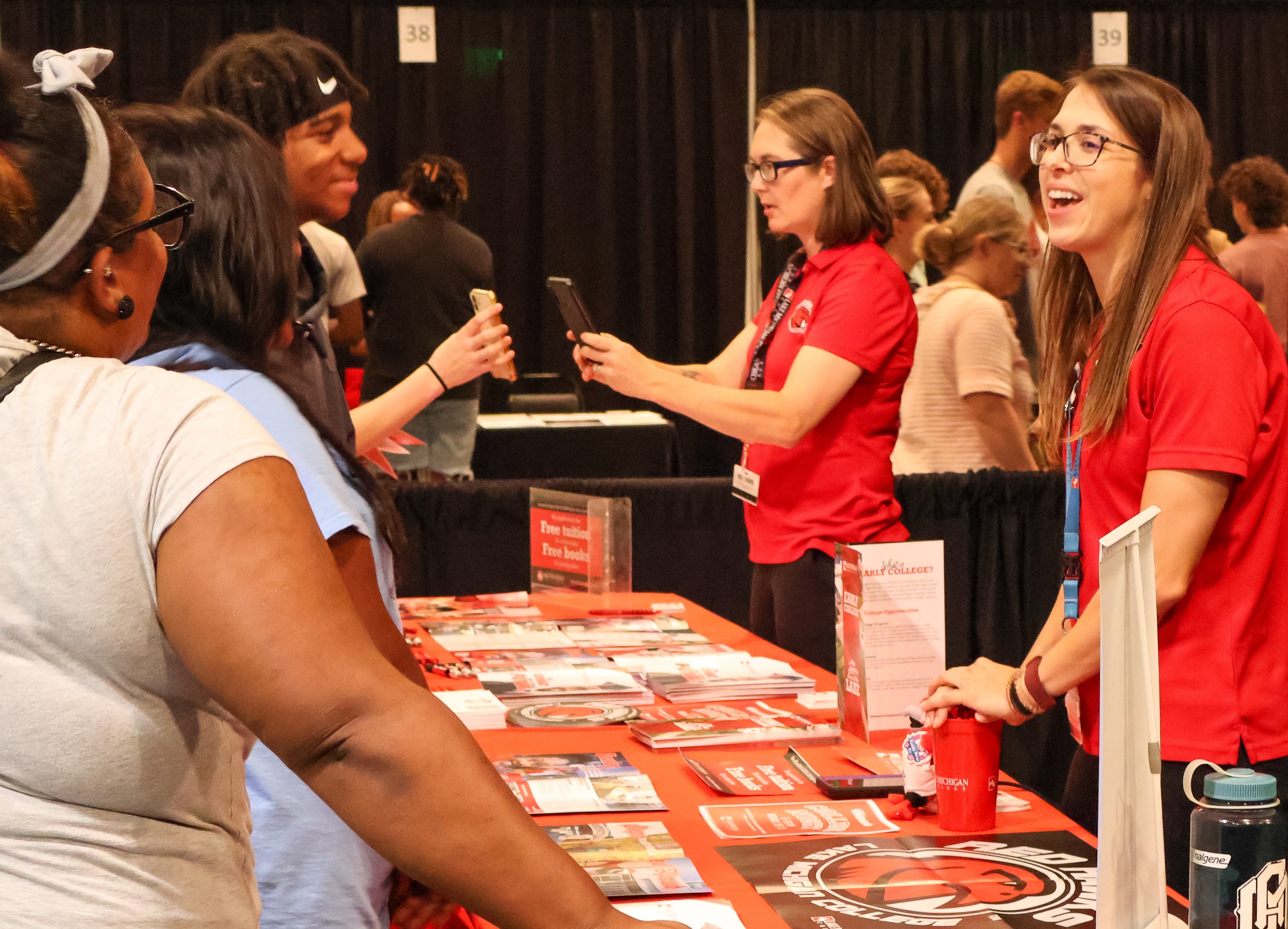 Students interact with presenters at a college fair. 