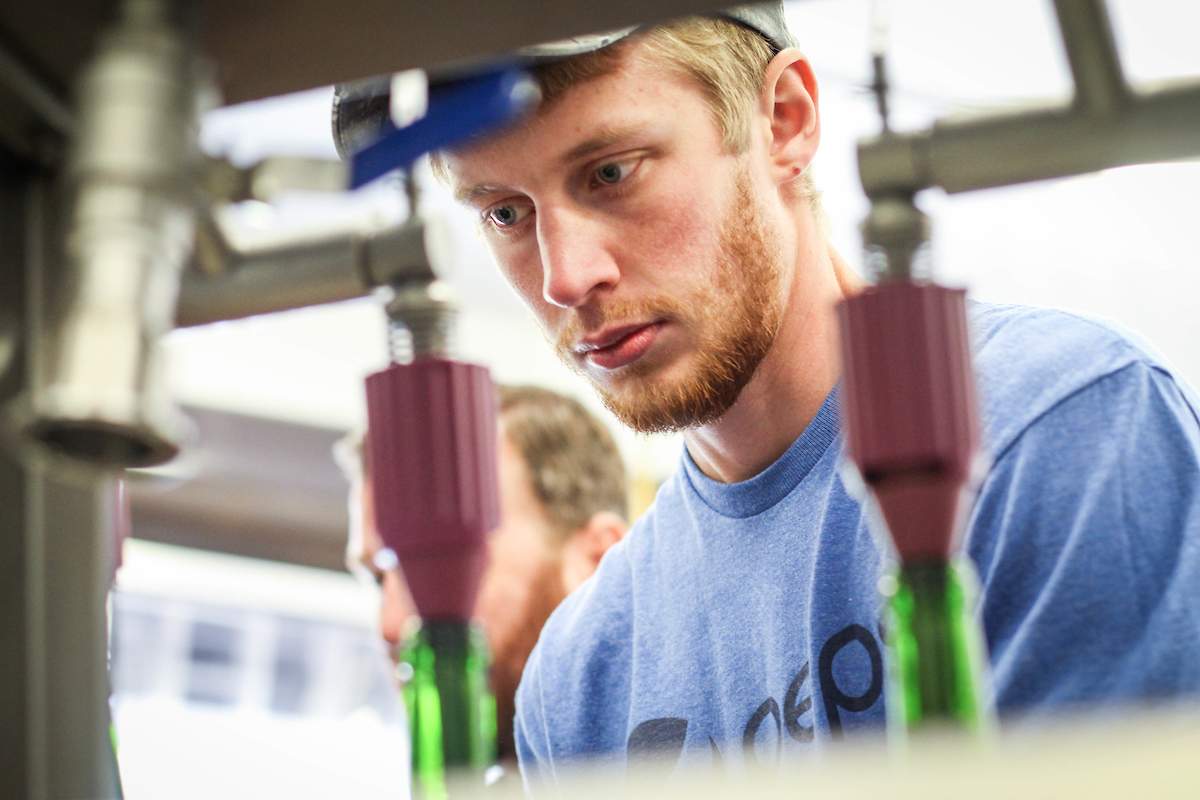 Student using a wine bottling machine