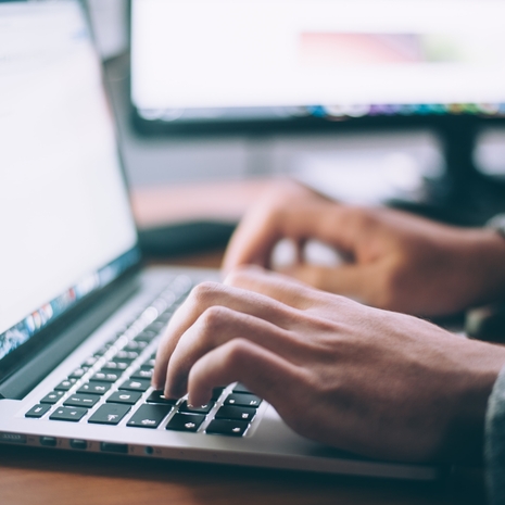 Link to contact form - image is of the hands of a person typing on a laptop.