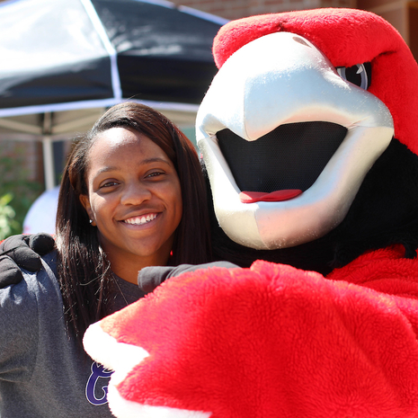 Rocky mascot with his arm around a student.
