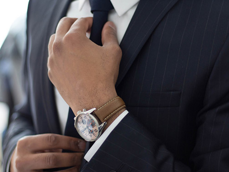 Person in a business suit adjusting their tie.