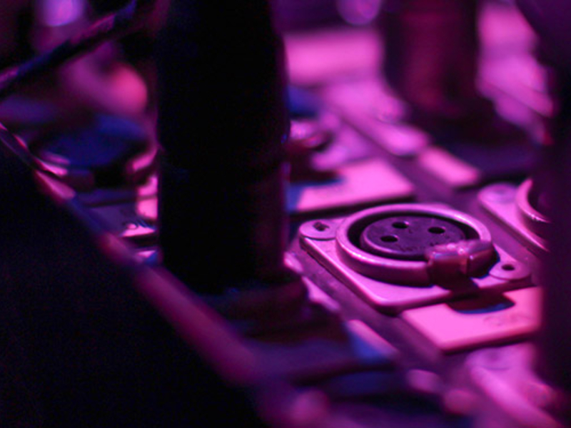 Sound equipment in a purple light from stage