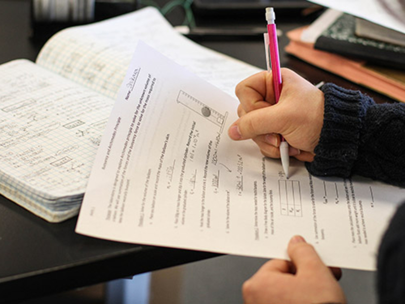 Student taking notes in a science lab