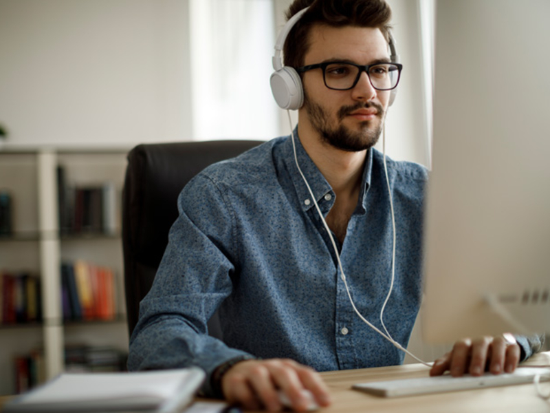 Person in headphones working on a large monitor.