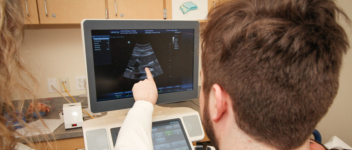 Sonography student studies ultrasound image