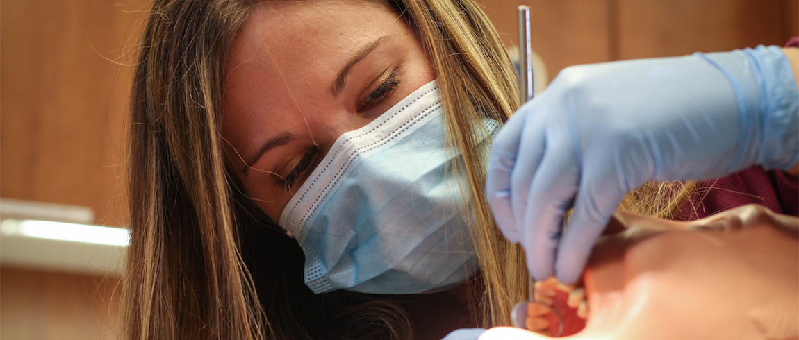 Dental assisting student working on a mannequin