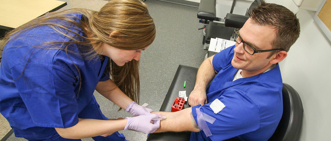 Phlebotomy students practice on each other