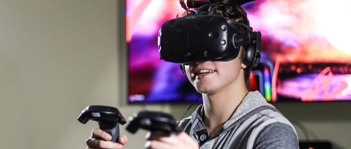 Student using VR goggles and gaming equipment Student using VR goggles and gaming equipment