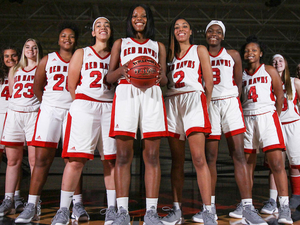 women's basketball team posing in the LMC gymnasium