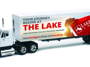 Semi truck with Lake Michigan College graphic wrapped around trailer.