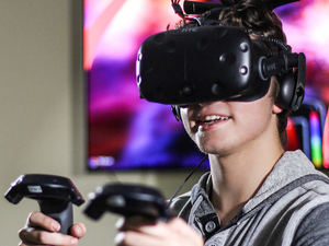 Student using VR goggles and gaming equipment