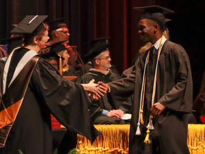 Lake Michigan College Board of Trustees Secretary Vicki Burghdoff congratulates a graduating student during the 75th commencement ceremonies on May 1, 2022.