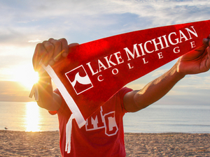 Beach, sun, person, Lake Michigan College flag