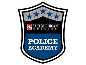 Shield-shaped Lake Michigan College Police Academy logo featuring five blue stars across the top, the Lake Michigan College name and red wave emblem in the center, and the words ‘Police Academy’ in bold white letters on a blue background at the bottom